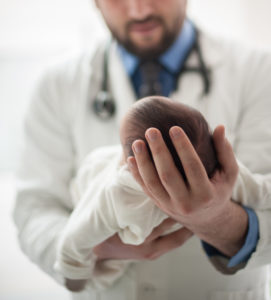 A doctor holding a newborn baby