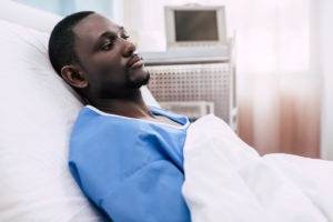 black man lying in a hospital bed