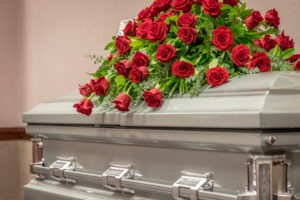 casket with red roses on top