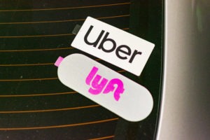 Uber and Lyft stickers on a car’s back window